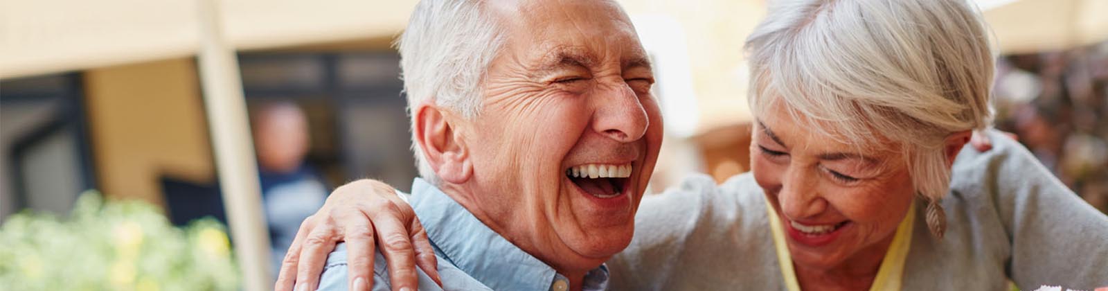 senior couple embracing while laughing outside
