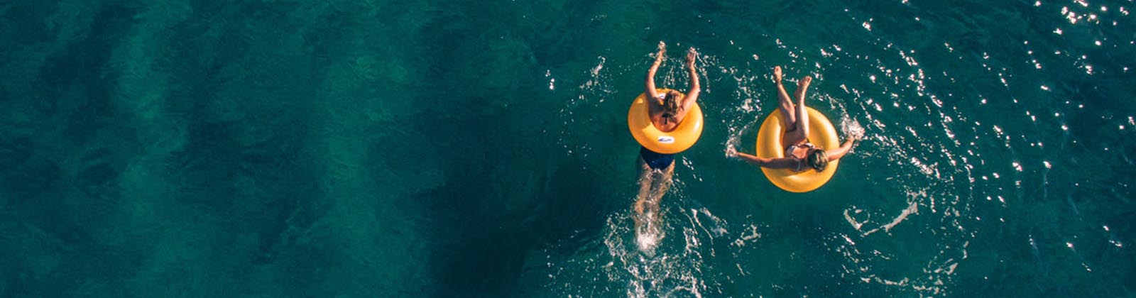 two people floating in inner tubes on the water