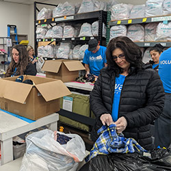 Advantis team members volunteering in the With Love warehouse, sorting and organizing donated supplies.