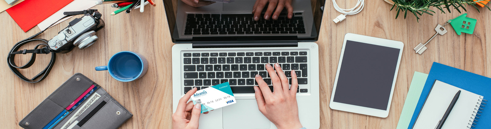 Person holding credit card while using laptop